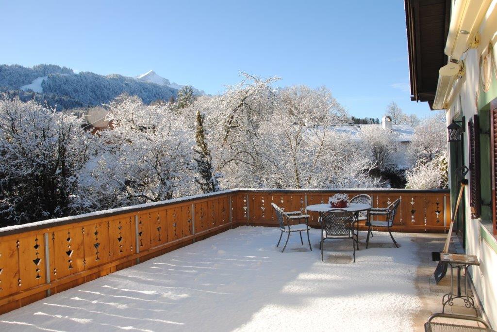 Snow-covered roof terrace with mountain view