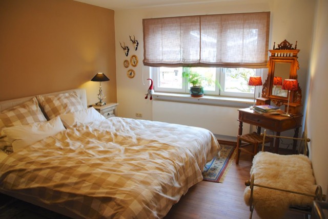 Schlafzimmer mit Frisierkommode und Fensterblick
