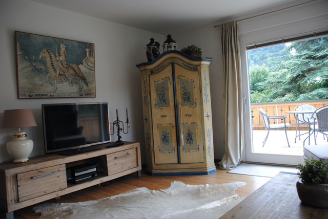Wohnzimmer mit Flachbild-TV und bemaltem Bauernschrank